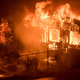 A firefighter sprays water as flames from a wildfire consume a residence near Oroville, California. (Image: AP/Noah Berger)